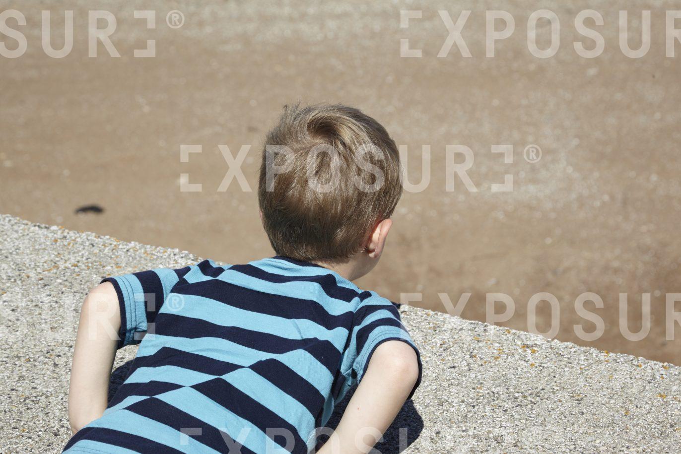 Boy looking over a wall