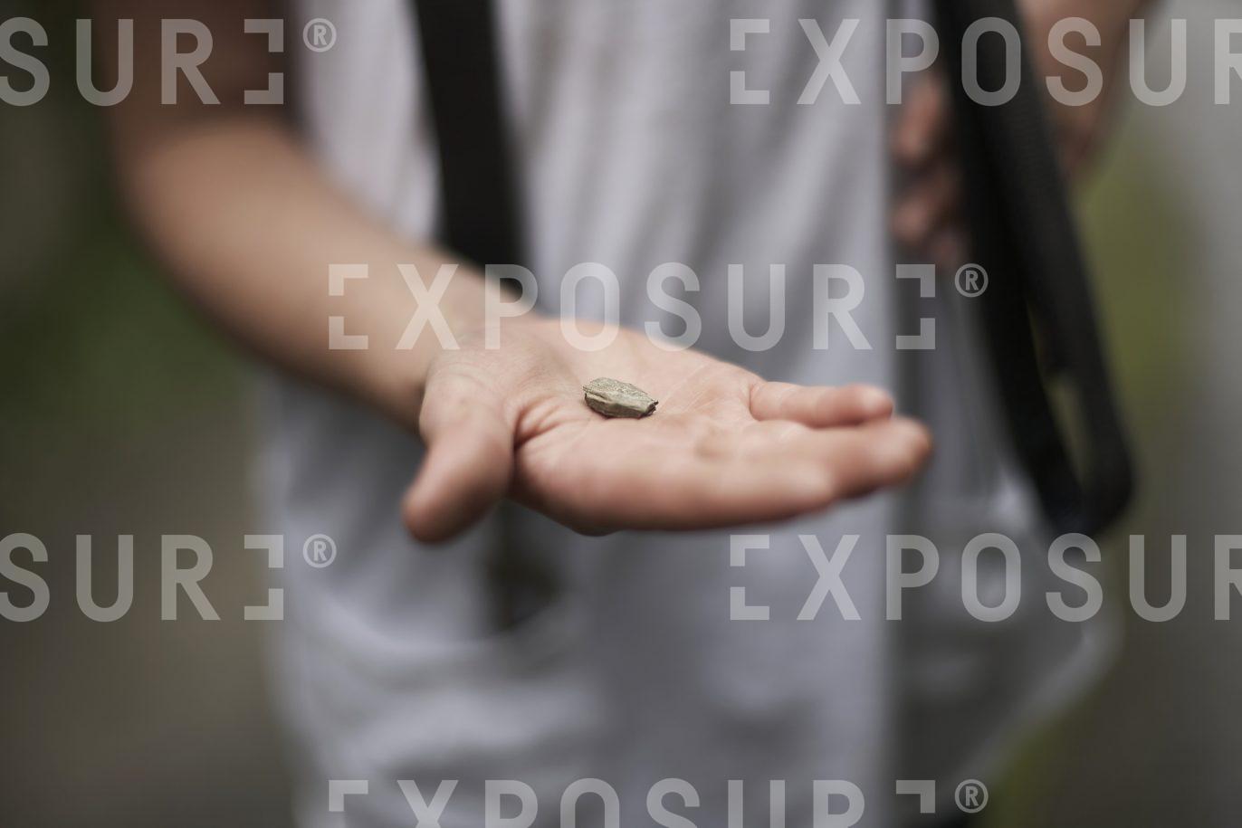 A girl holds a small pebble
